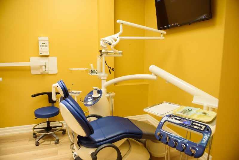 A Dental Chair with a yellow background in the Smile Horizon Dental Arts office.